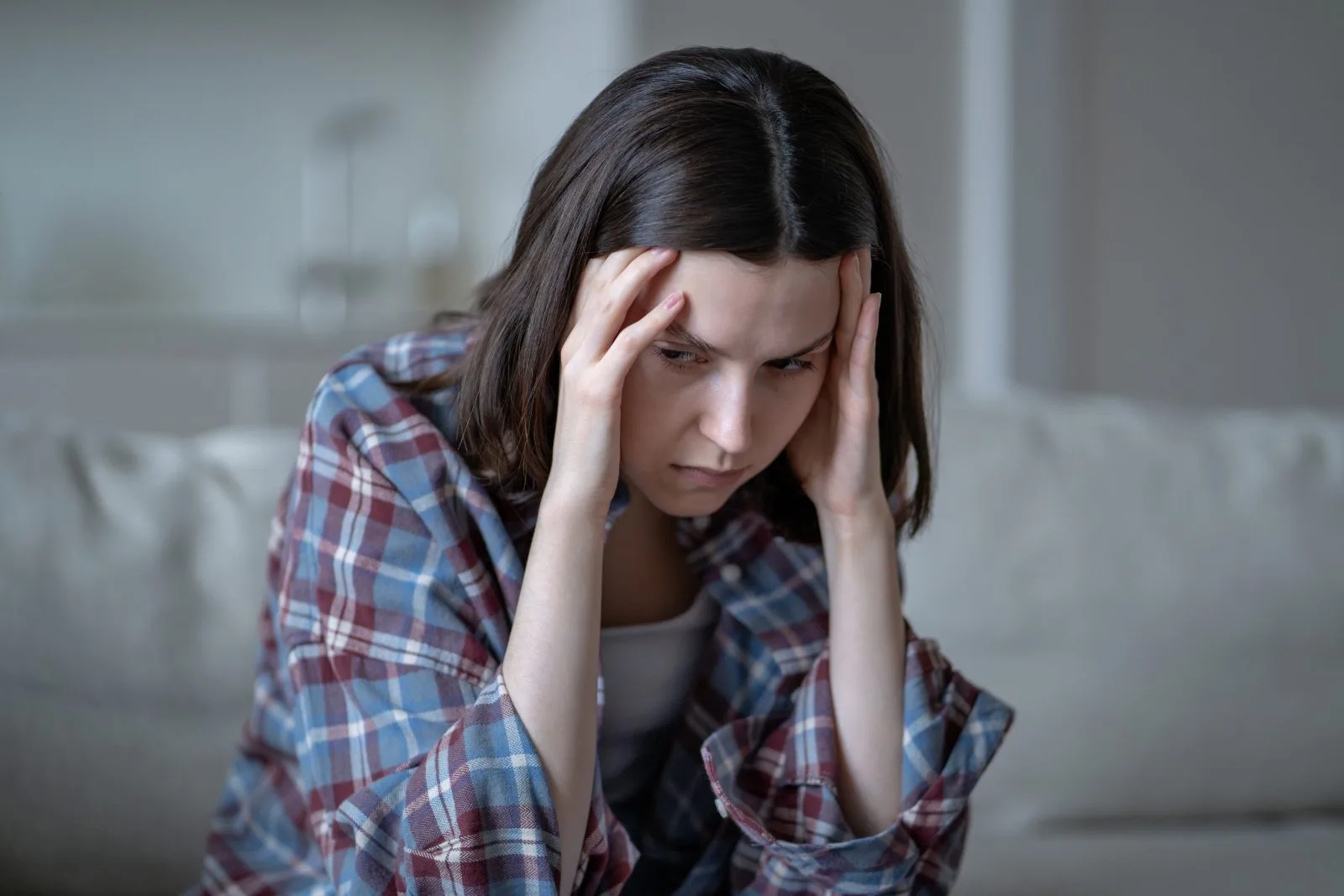 Woman holding her head in distress – online psychiatry in Tacoma, WA